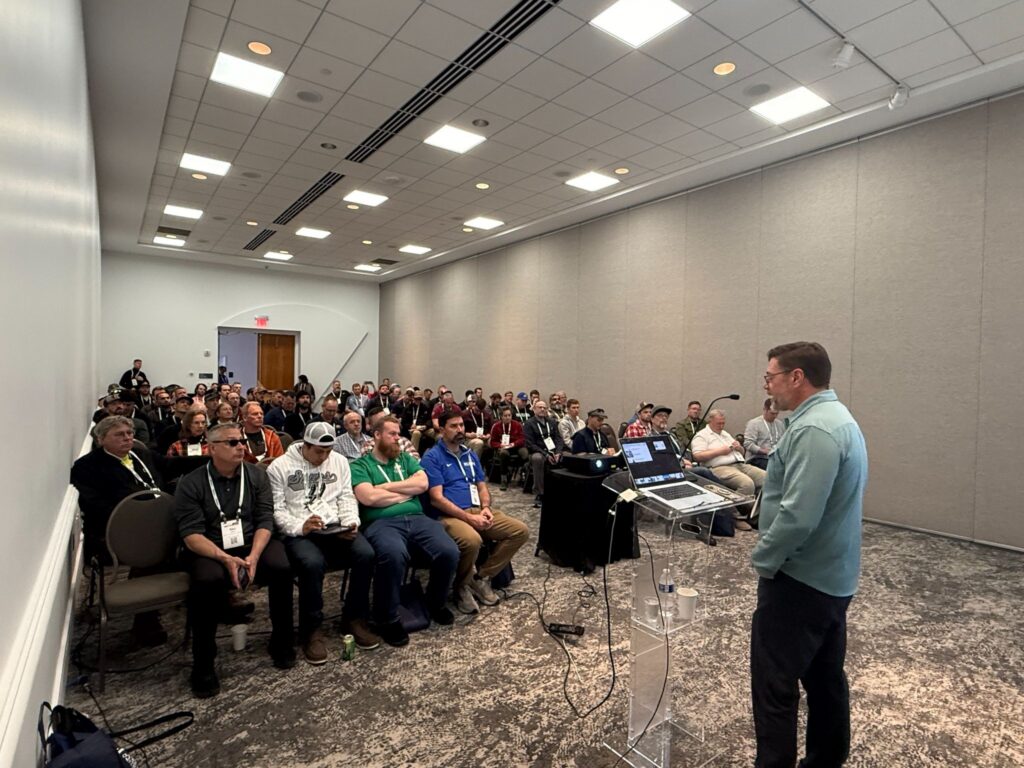 an instructor speaking to a filled classroom at a conference